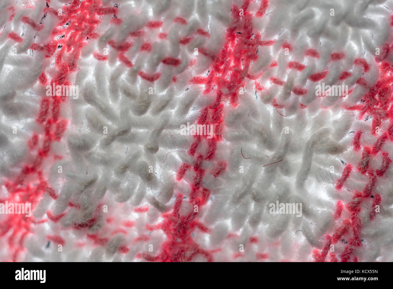 Gros plan, flou, adouci, sur les fils de gauchissement et de trame d'un teacloth rouge et blanc. Résumé rouge. Banque D'Images