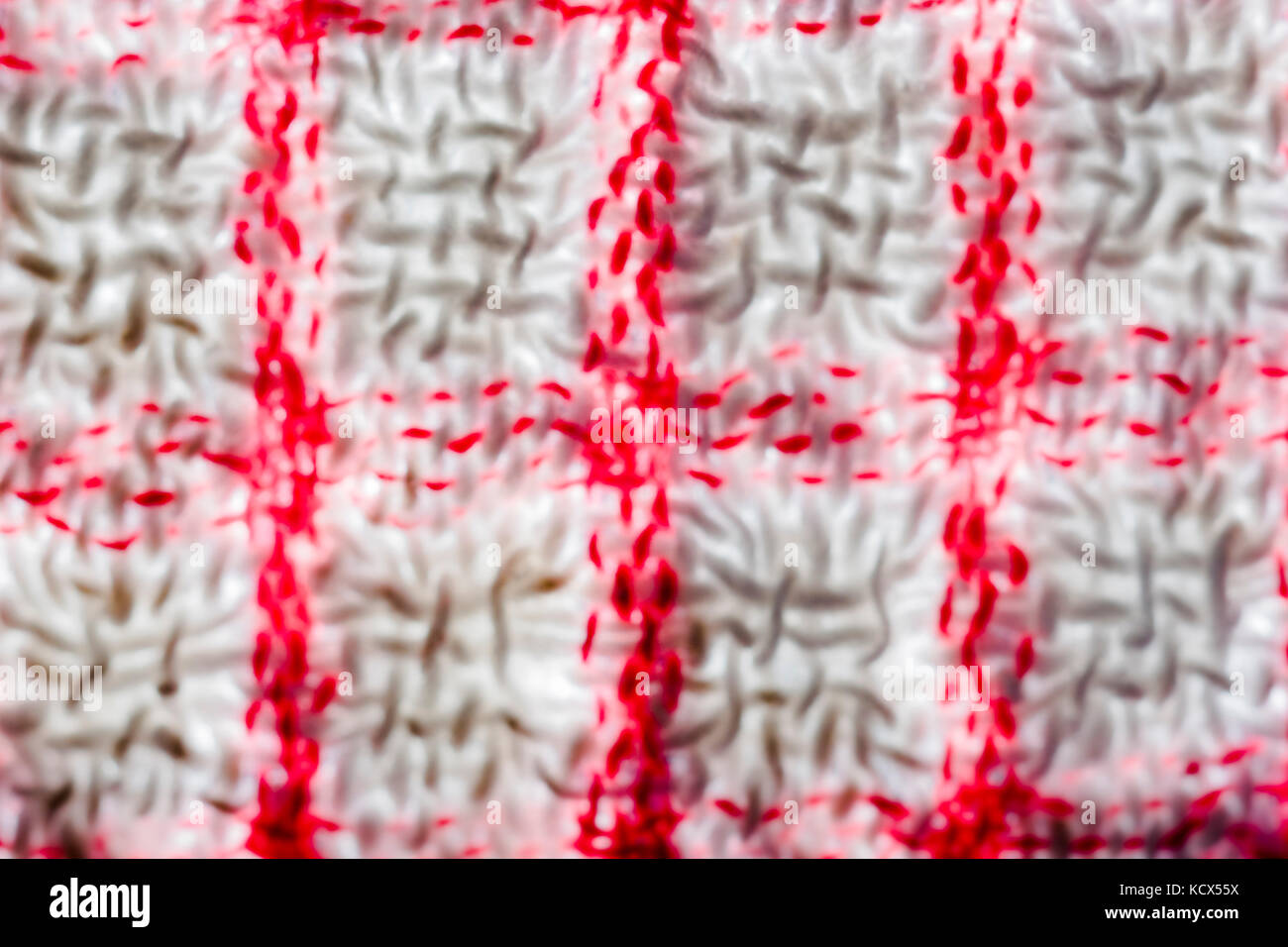Adouci, floue, close-up plan macro sur la chaîne et la trame d'un teacloth rouge et blanc. Banque D'Images
