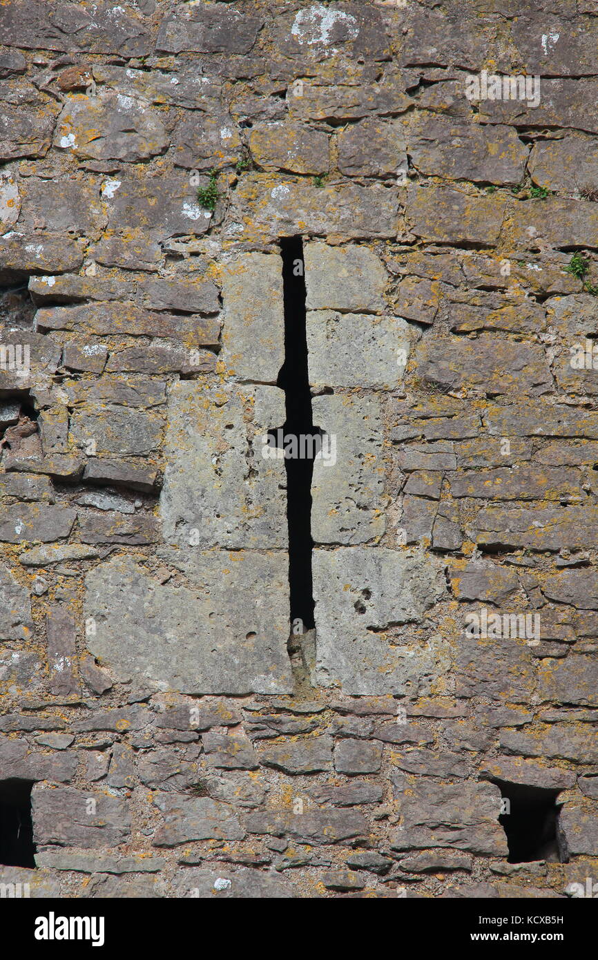 Une coupe très précise d'archers fente dans le côté d'un château en ruines montrant de façon très précise des pierres de taille, permettant aux archers de flèches de feu au-delà des murs. Banque D'Images