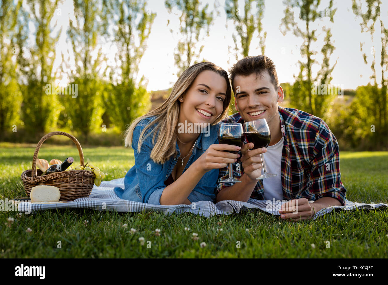 Prise d'un beau couple sur le parc faire un pique-nique et de boire du vin Banque D'Images