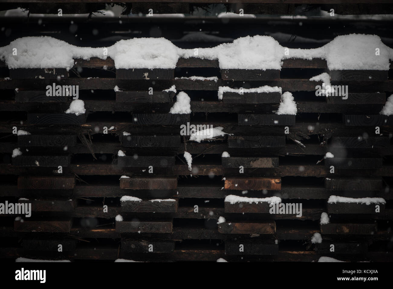 Des piles de bois de construction en hiver, recouvert de neige Banque D'Images