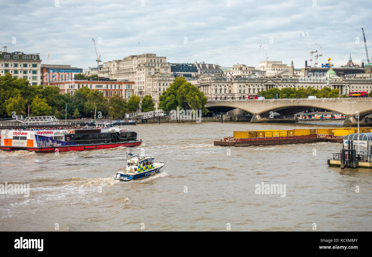 La police maritime, de la Force de police de la rivière Thames (bateau d'intervention rapide) à la poursuite d'un chaland chargé à la tête de la Tamise à Londres, Angleterre, Royaume-Uni. Banque D'Images