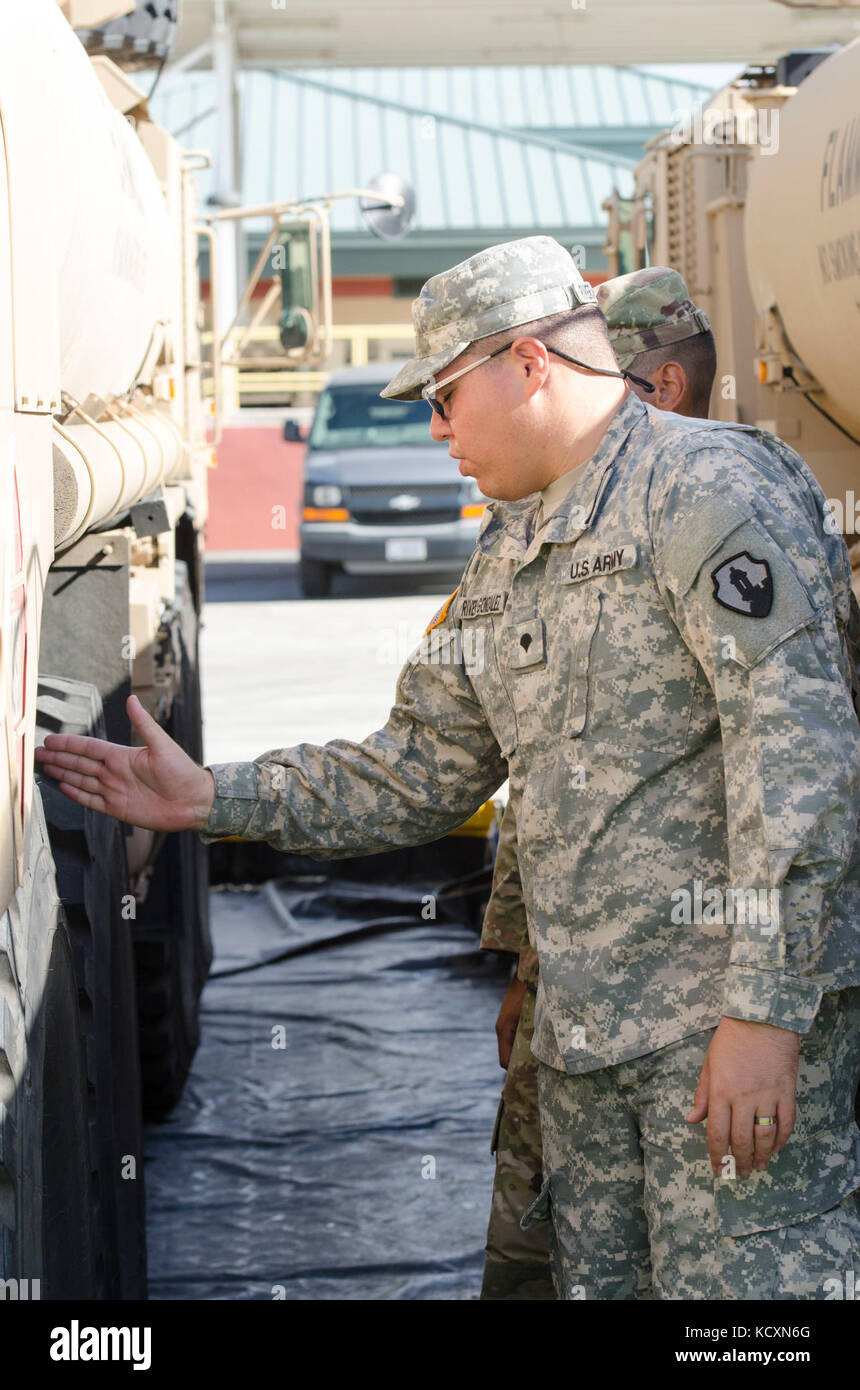 Réserve de l'armée américaine de la CPS. Kelvin Rivera Gonzalez, un spécialiste de l'approvisionnement en pétrole, affecté à la 941e compagnie de quartier-maître, 346e, 166e bataillon de transport Groupe de soutien régional, 1ère Commande de soutien de mission, hors de Salinas, Porto Rico, examine les contrôles de maintenance préventive et des services processus avec réserve de l'armée nouvellement affectés Pvt. Caleb Gonzalez, également un spécialiste de l'approvisionnement en pétrole, affecté à la 941e, QM à Fort Buchanan, Puerto Rico, 5 octobre 2017. Rivera a fait partie de l'exécution avec succès plus de 100 000 gallons de carburant diesel pour les hôpitaux et les cliniques communautaires. (U.S. Ar Banque D'Images