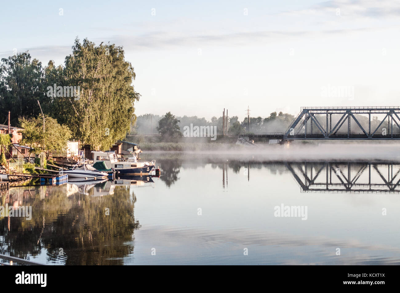 Petit port. Beau matin brouillard sur le lac. Réflexions du pont. Banque D'Images