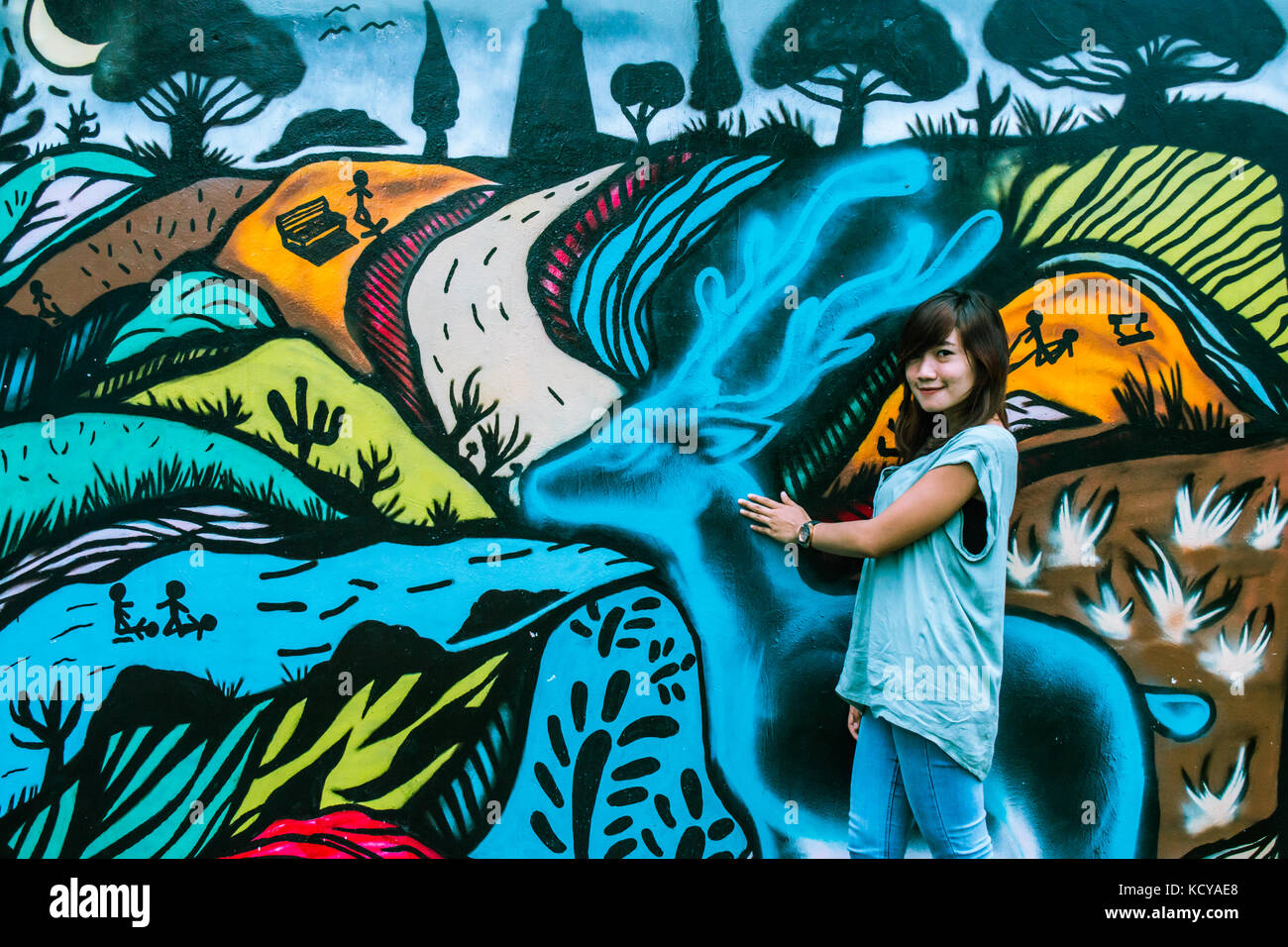 Une jeune et belle jeune fille contre un mur de graffiti Banque D'Images