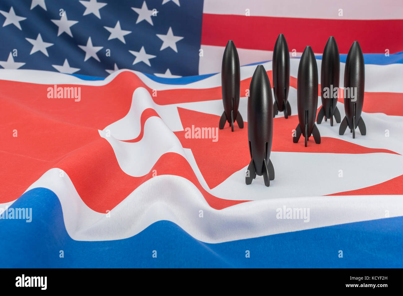 Toy Rocket + drapeau américain, drapeau nord-coréen - métaphore pour les sommets de la Corée du Nord, le sommet Trump NOKO / Kim Jong un, les armes nucléaires de la Corée du Nord. Banque D'Images