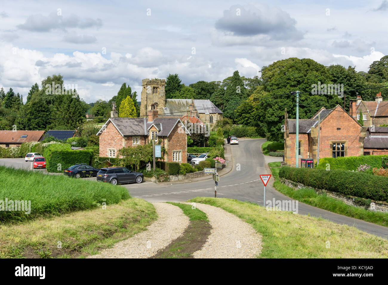 Vue sur la rue principale à travers le village de Felixkirk avec la tour de l'église de St Felix dans l'arrière-plan ; Yorkshire, UK Banque D'Images