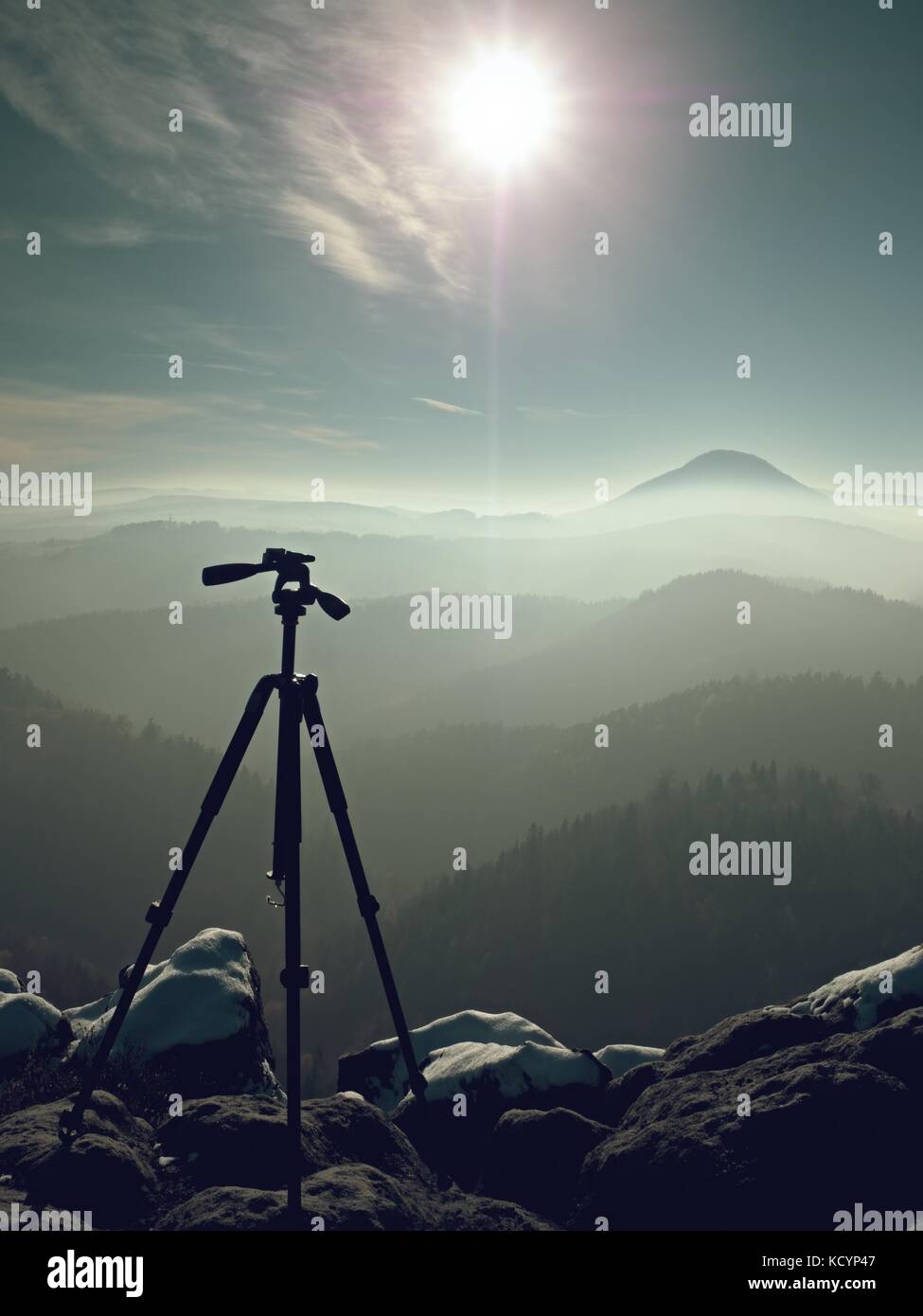 Sur le pic de trépied prêt pour la photographie. sharp automne pics rocheux wit première neige, des collines est passé de brouillard dans clorful profonde vallée ci-dessous. Banque D'Images