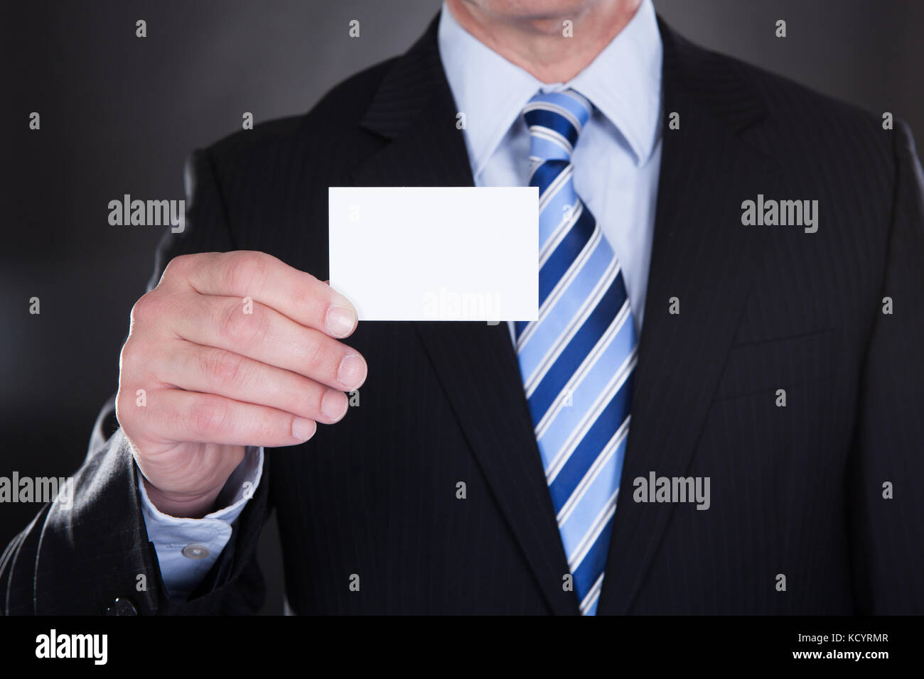 Close-up of Businessman Holding sur fond noir Carte de visite Banque D'Images