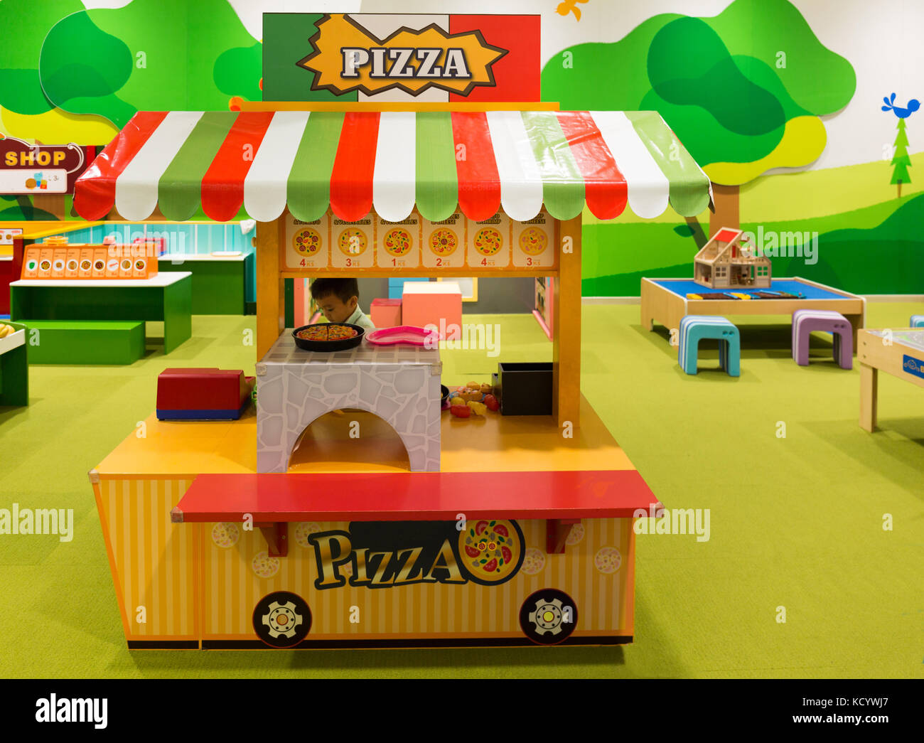 Petit garçon jouet vente pizza dans une pizzeria à l'aire de jeux pour enfants. Banque D'Images