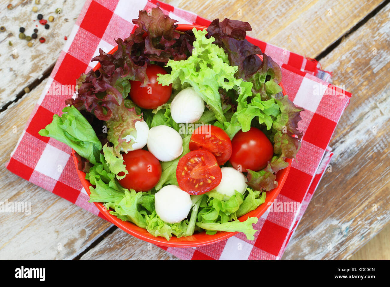 Salade de mozzarella bol en rouge sur la surface en bois rustique Banque D'Images