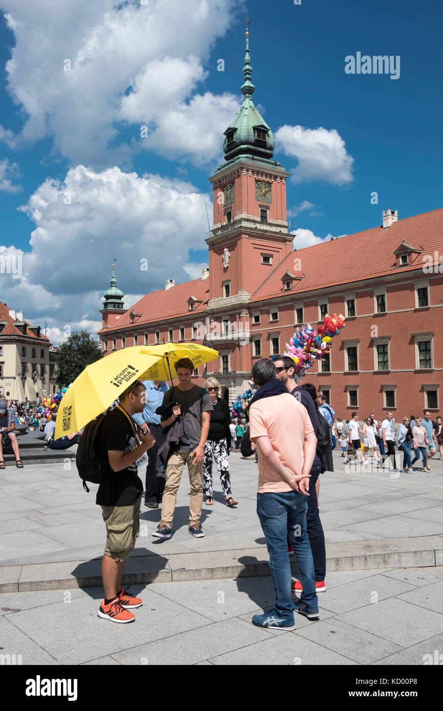 Des guides touristiques avec des parasols jaunes en face du Château Royal, en plac Zamkowy, la vieille ville de Varsovie, Pologne. Banque D'Images