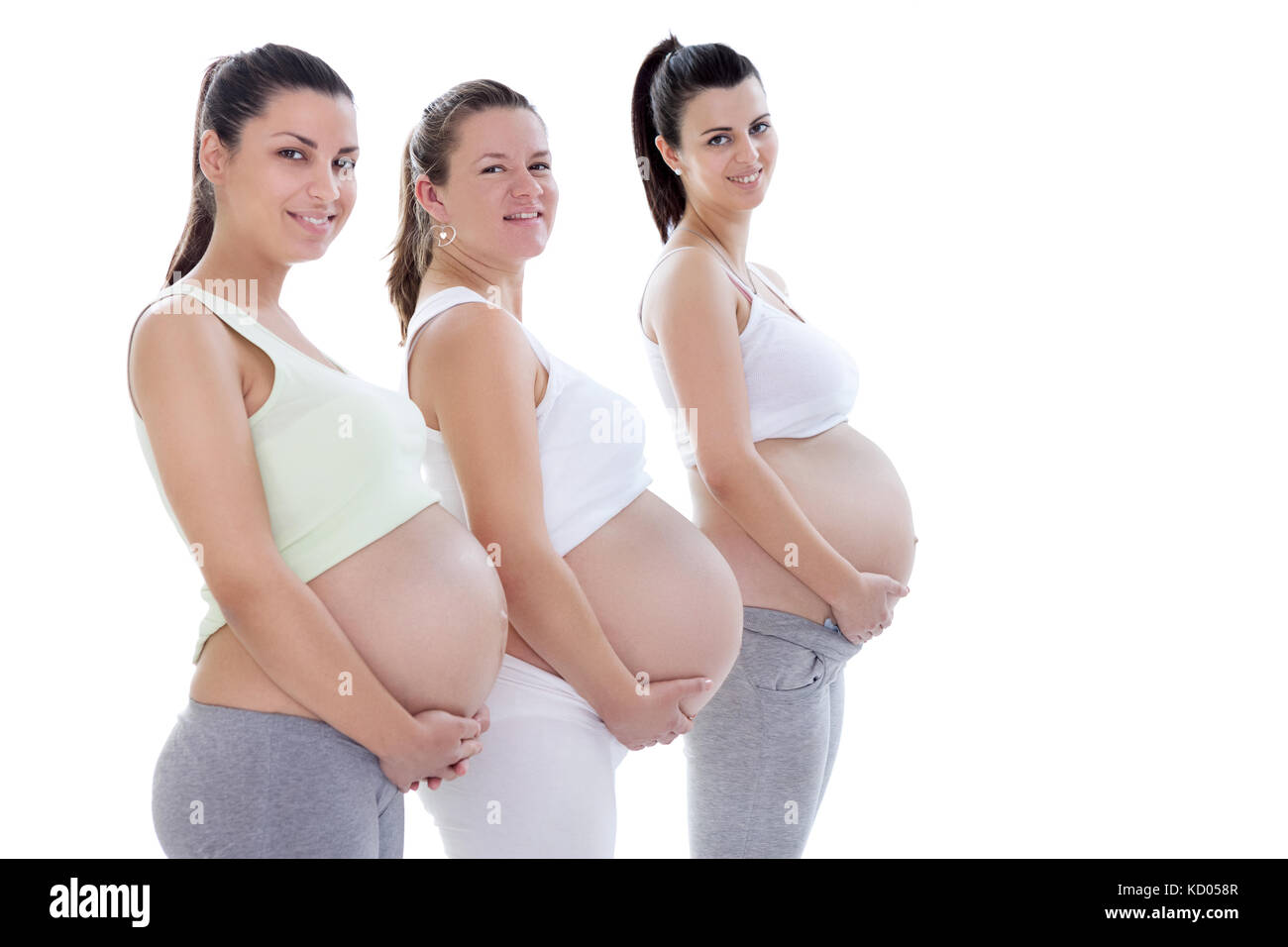 Les jeunes femmes enceintes dans le troisième trimestre smiling and looking at camera Banque D'Images