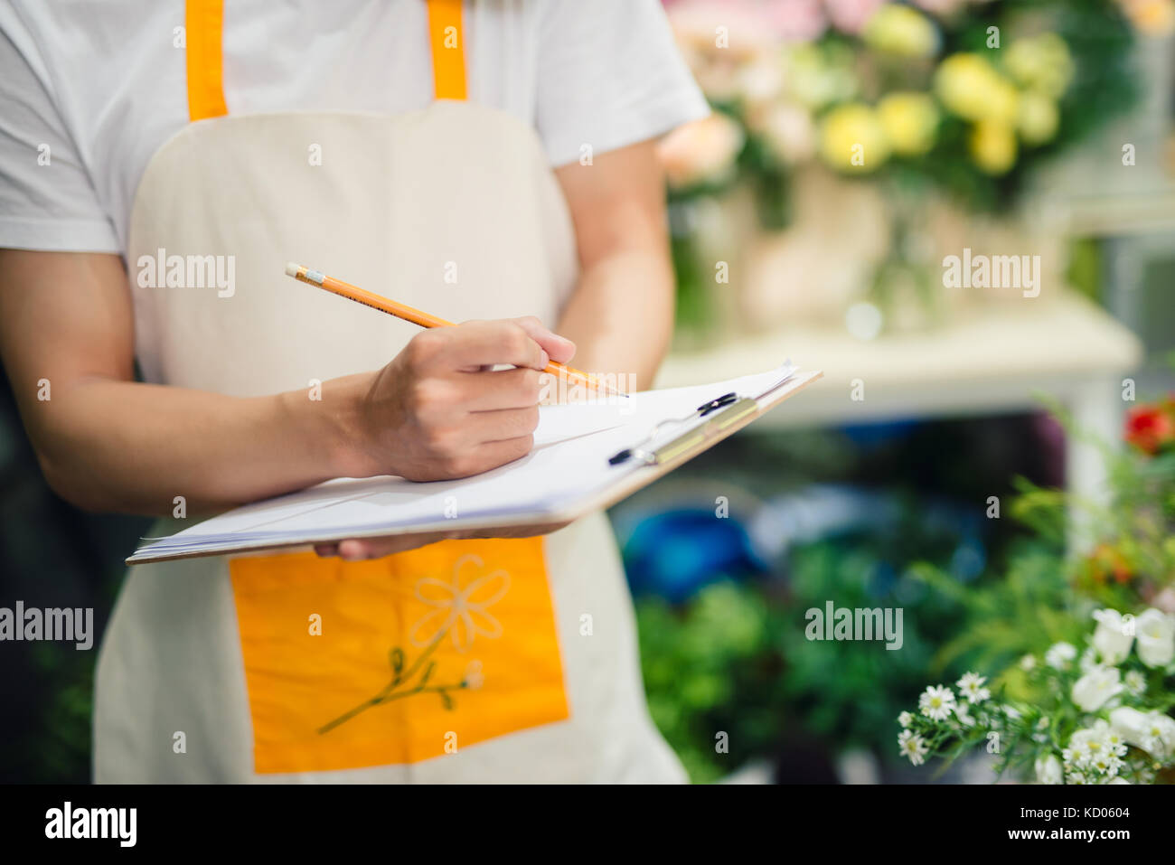 Portrait of asian male florist prendre des notes au comptoir du magasin de fleurs Banque D'Images