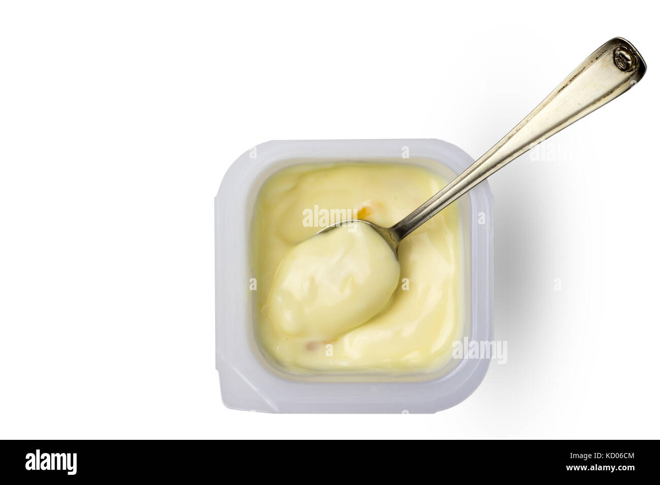 Abricot et pêche jaune crème yogourt en peu synthétique avec petite cuillère en argent - top view image de yogourt aux fruits en pot isolé sur zone blanche Banque D'Images