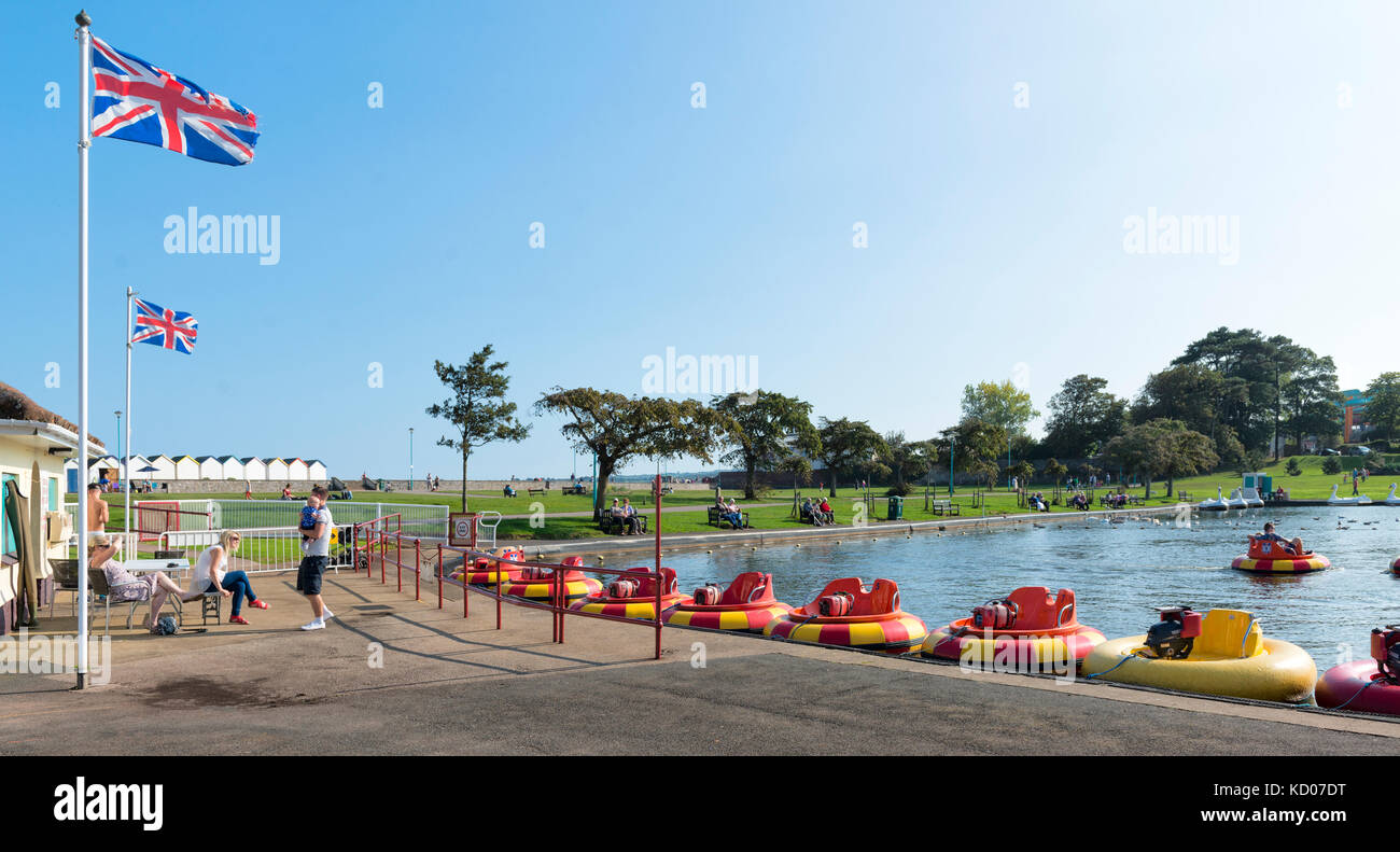 Bateaux tamponneurs motorisé au lac de plaisance de goodrington, Young's Park, Paignton, Devon, Torbay. u les vacanciers, cabines de plage, les drapeaux de l'été. Banque D'Images