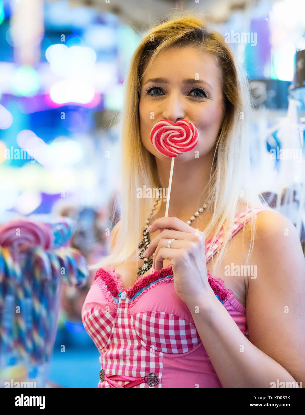 Blonde woman in dirndl rose avec une sucette en forme de coeur, l'Oktoberfest, Munich, Haute-Bavière, Bavière, Allemagne Banque D'Images