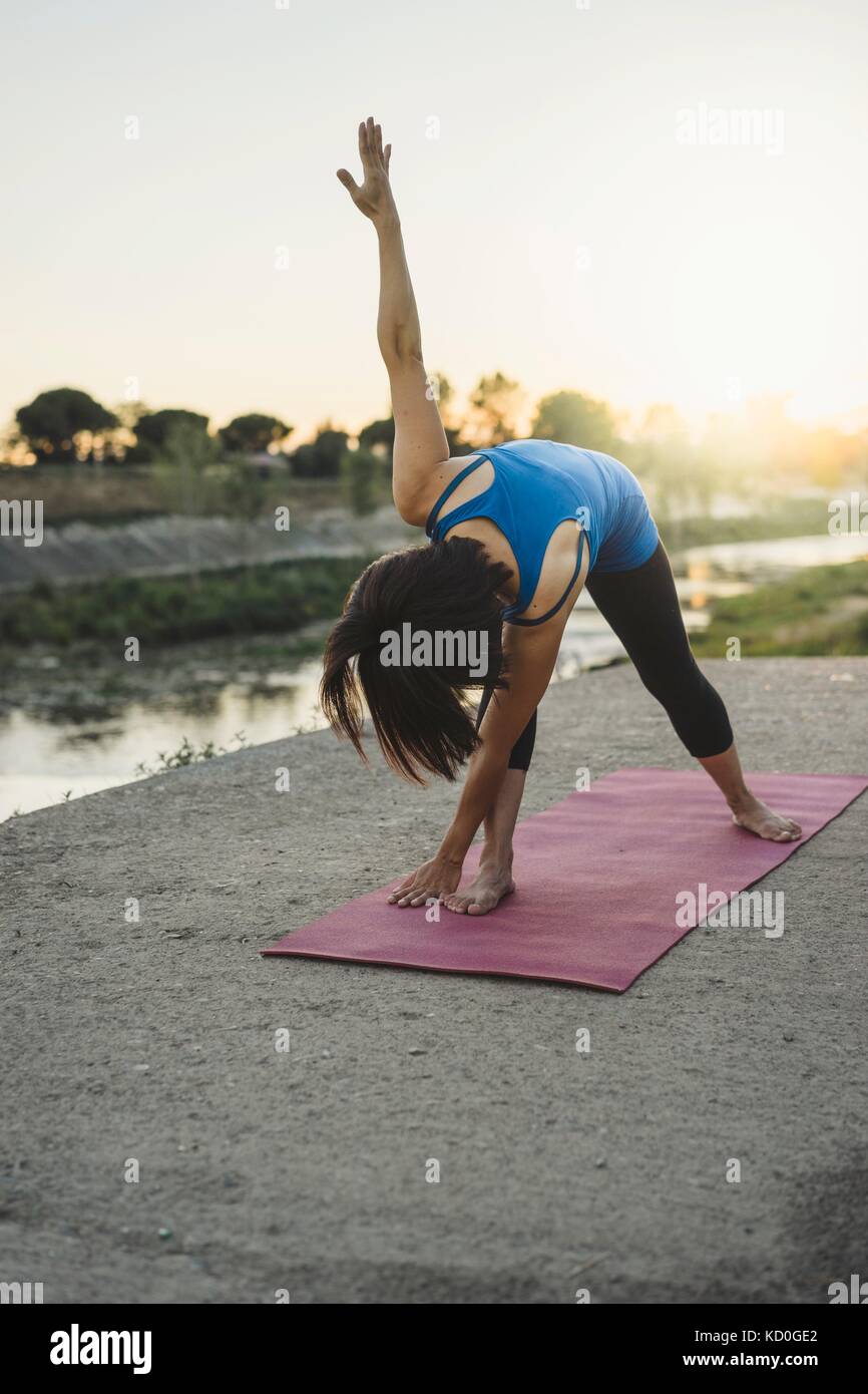 Femme mature en plein air, se plier plus in yoga position Banque D'Images