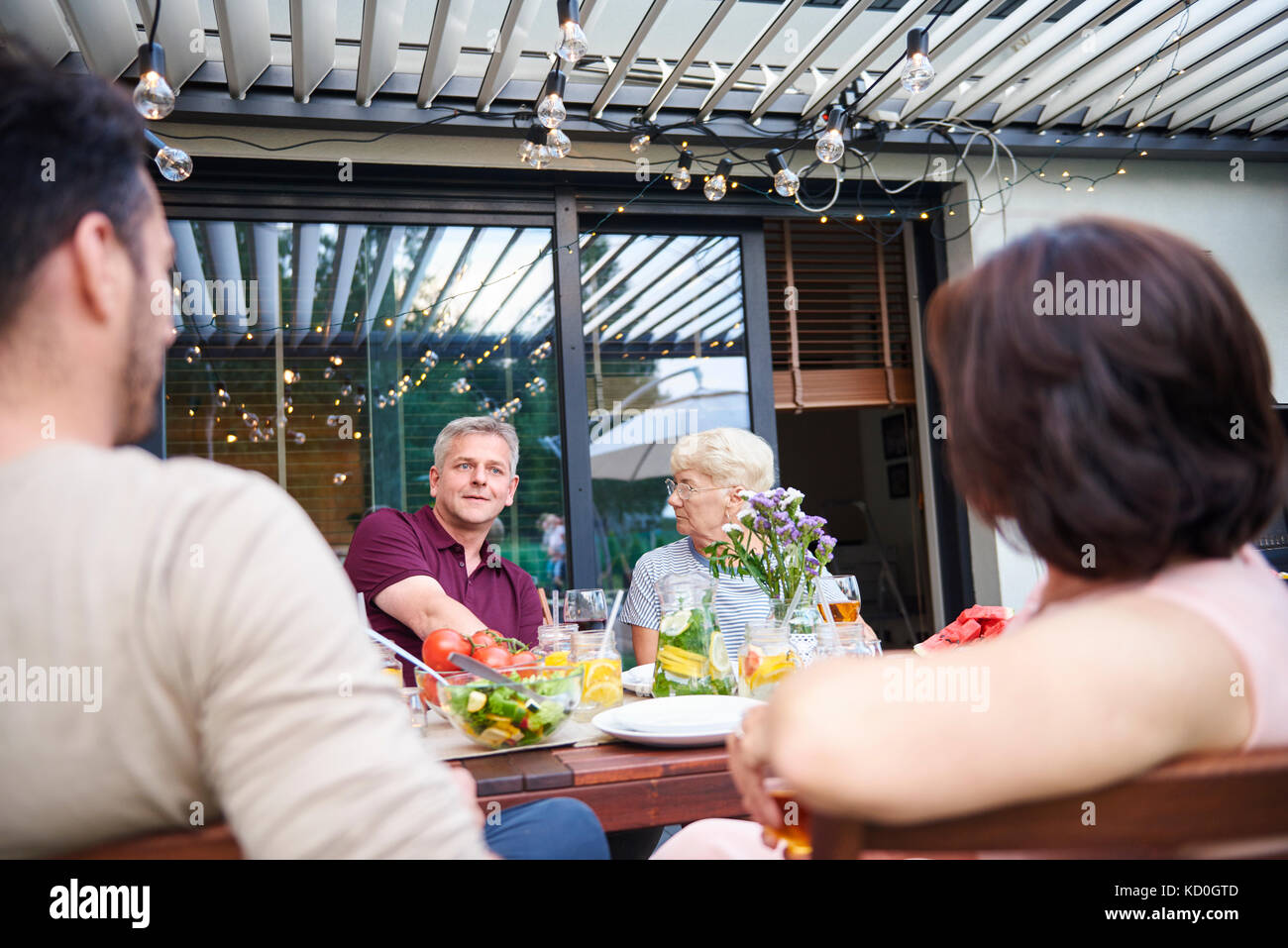 Plus d'épaule de hauts femme et homme mûr au déjeuner de la famille on patio Banque D'Images