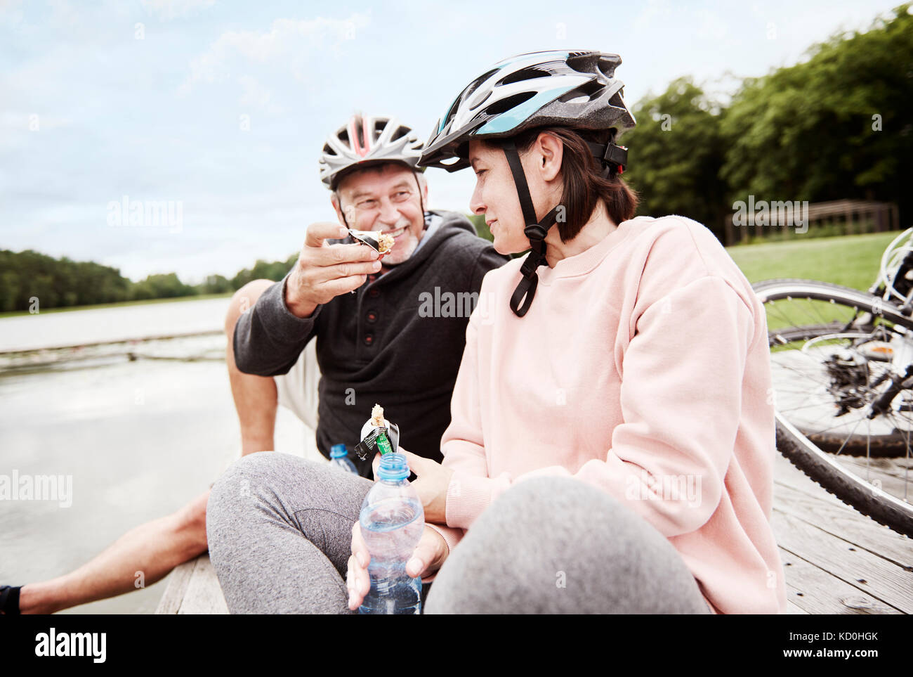 Young couple relaxing on Jetty, bénéficiant d''un snack-, vélos derrière eux Banque D'Images