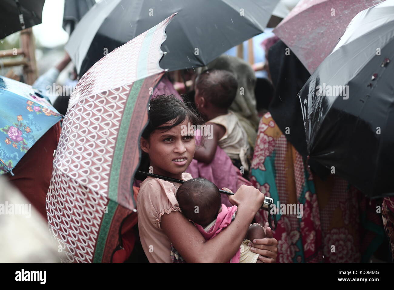 Teknaff, Bangladesh. 8 octobre 2017. Les Rohingyas attendent de l'aide alimentaire sous la pluie au camp de fortune de Palongngkhali à Teknaff, au Bangladesh, le 08 octobre 2017. Le Bangladesh a déclaré que ce serait l'une des plus grandes caméras de réfugiés au monde pour héberger tous les 800 000 musulmans Rohingyas plus qui ont demandé l'asile après la violence au Myanmar. Crédit : Zakir Hossain Chowdhury/ZUMA Wire/Alamy Live News Banque D'Images