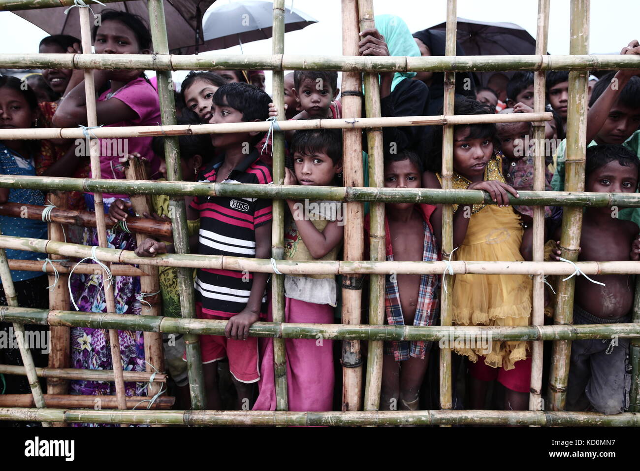 Teknaff, Bangladesh. 8 octobre 2017. Les Rohingyas attendent de l'aide alimentaire sous la pluie au camp de fortune de Palongngkhali à Teknaff, au Bangladesh, le 08 octobre 2017. Le Bangladesh a déclaré que ce serait l'une des plus grandes caméras de réfugiés au monde pour héberger tous les 800 000 musulmans Rohingyas plus qui ont demandé l'asile après la violence au Myanmar. Crédit : Zakir Hossain Chowdhury/ZUMA Wire/Alamy Live News Banque D'Images