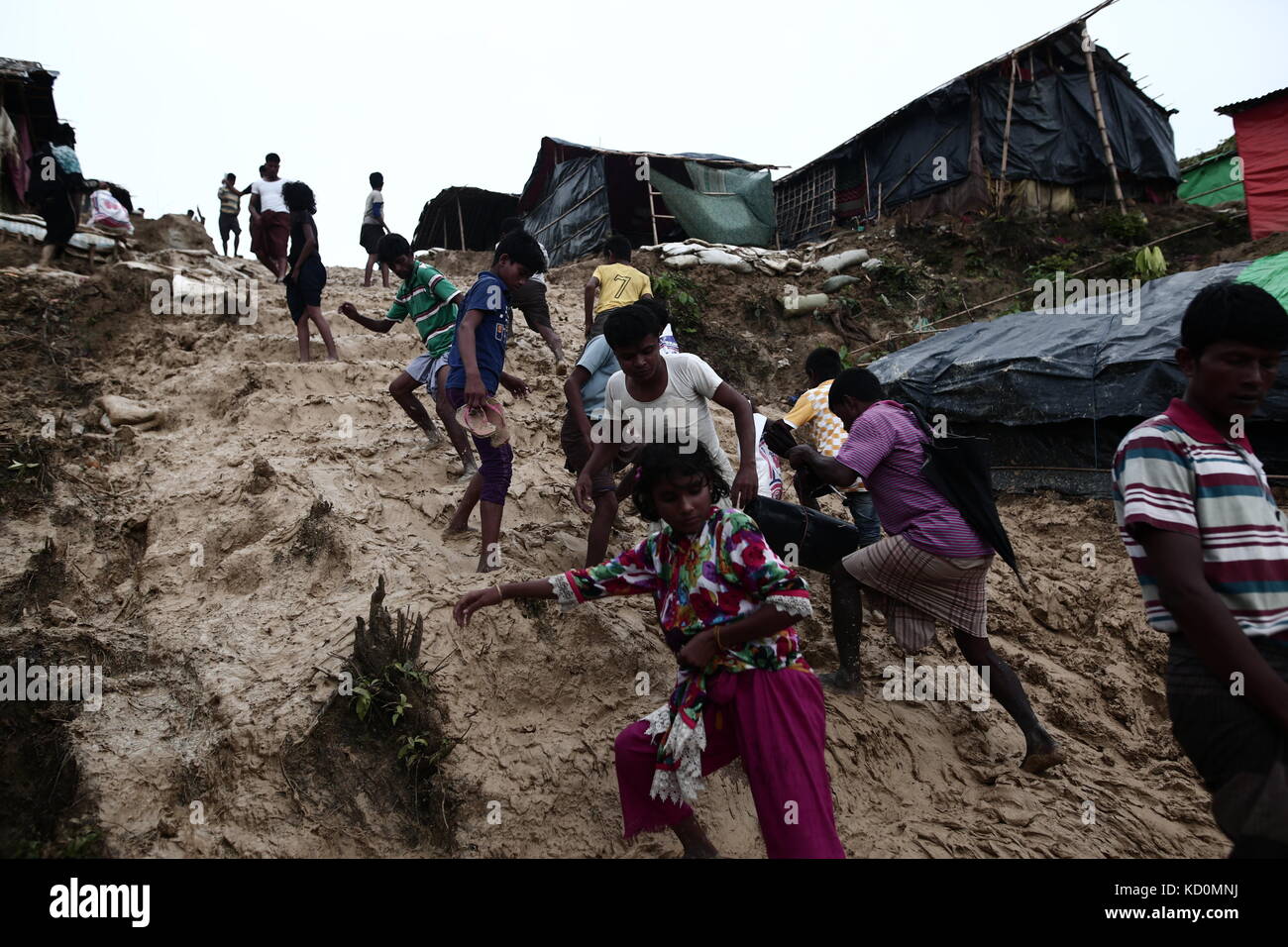 Teknaff, Bangladesh. 8 octobre 2017. Les Rohingyas marchent sur une route de boue argileuse après la pluie au camp de fortune de Palongngkhali à Teknaff, au Bangladesh, le 08 octobre 2017. Le Bangladesh a déclaré que ce serait l'une des plus grandes caméras de réfugiés au monde pour abriter les 800 000 musulmans Rohingyas qui ont demandé l'asile contre la violence au Myanmar. Crédit : Zakir Hossain Chowdhury/ZUMA Wire/Alamy Live News Banque D'Images