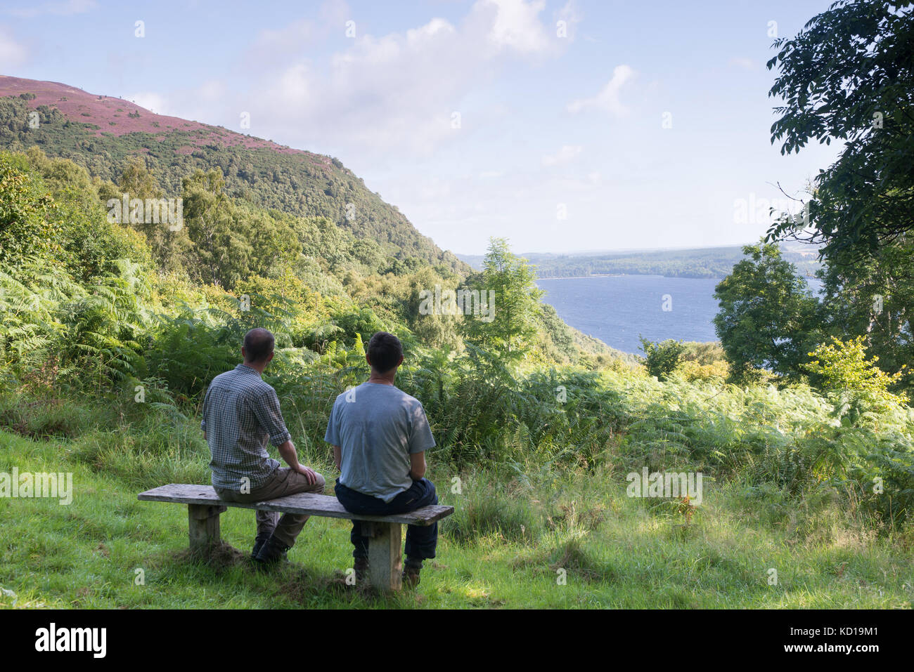 Les promeneurs assis sur un siège à Abriachan bois Près de Drumnadrochit à au Loch Ness, en Ecosse. Banque D'Images