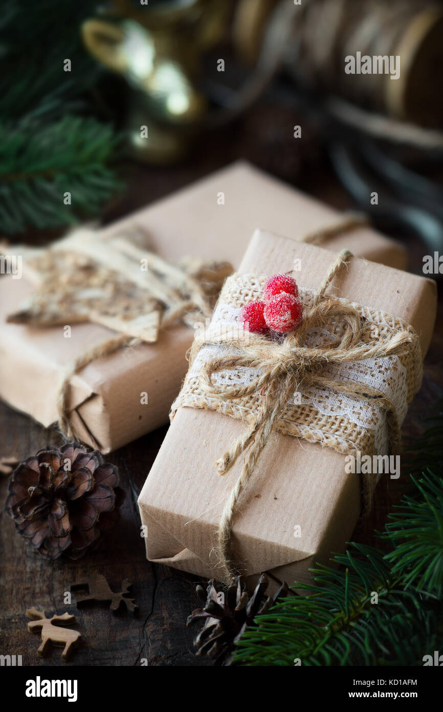 Cadeaux de Noël enveloppé dans du papier craft marron avec des décorations de fête Banque D'Images