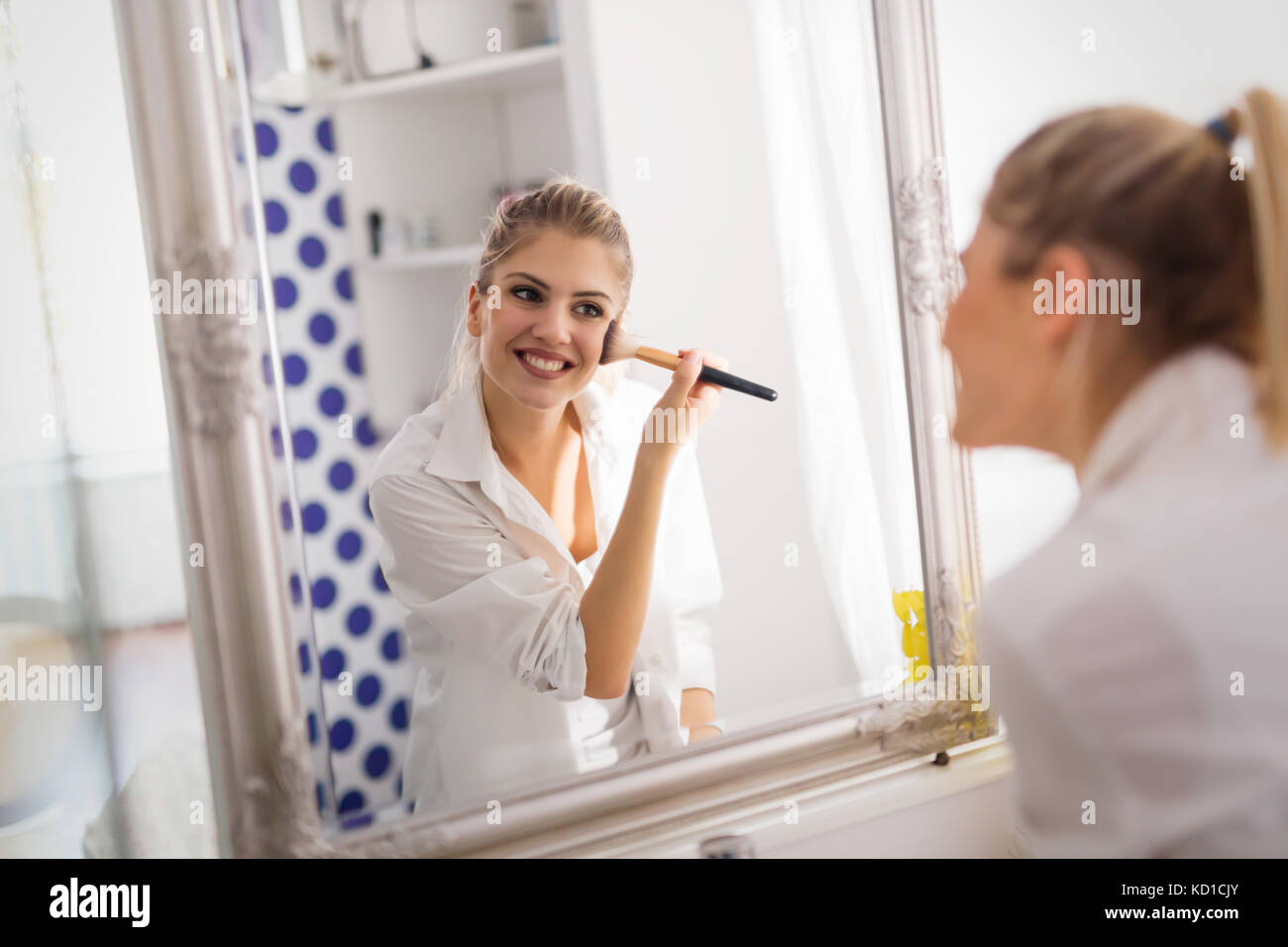 Belle fille de salle de bains appliquant le maquillage Banque D'Images