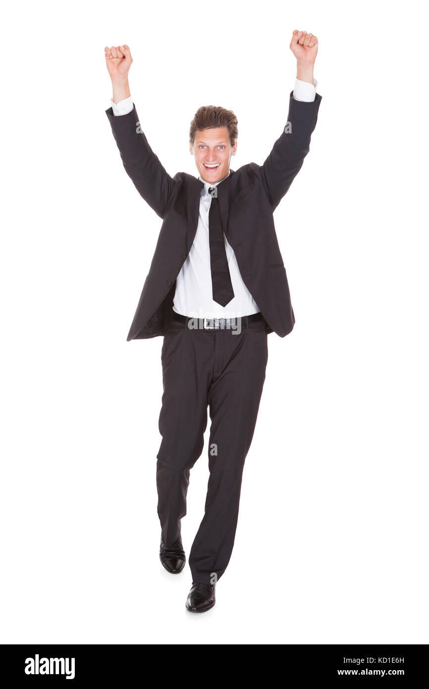 Jeune homme d'excités avec bras levé debout sur fond blanc Banque D'Images