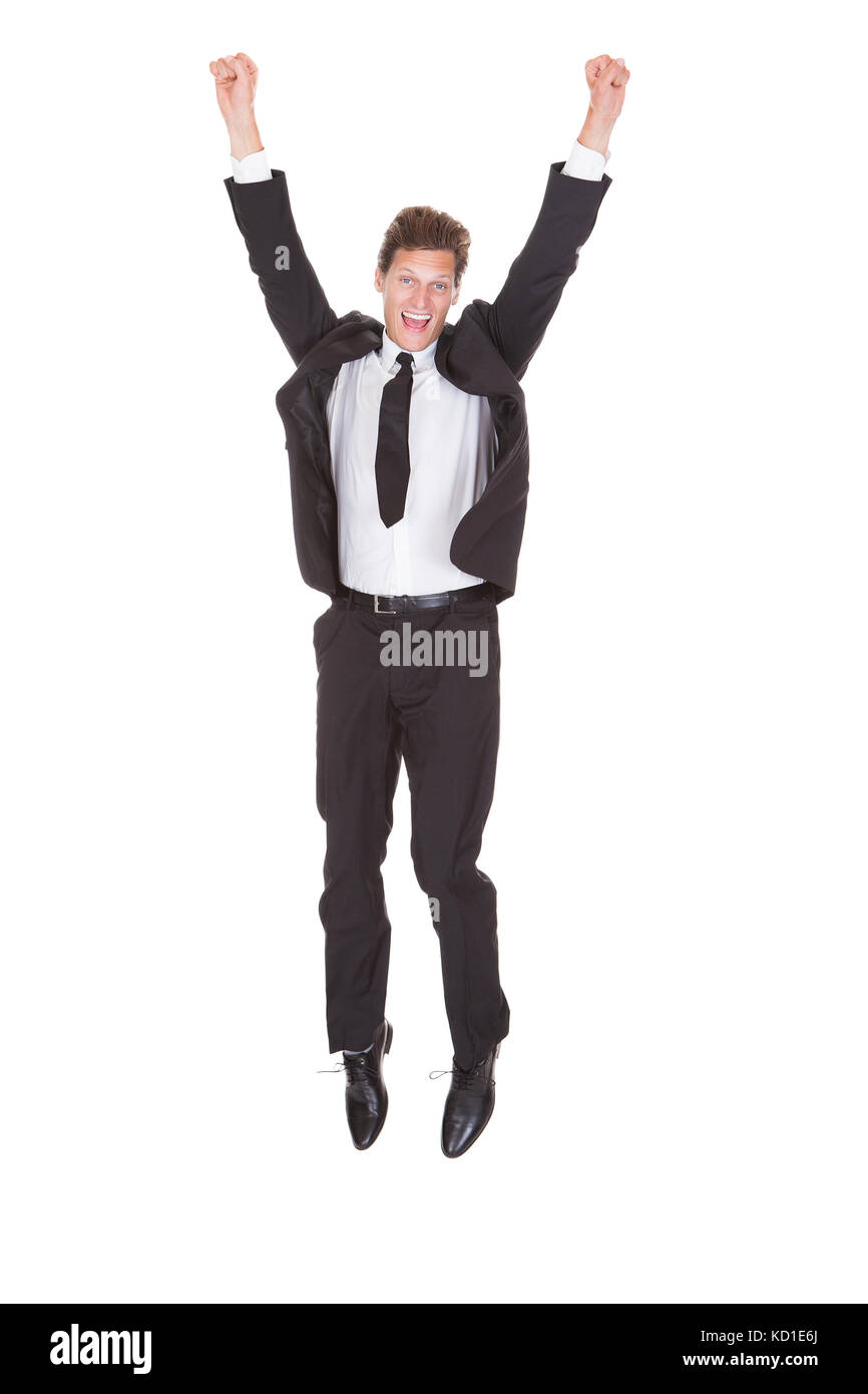Jeune homme d'excités avec bras levé debout sur fond blanc Banque D'Images