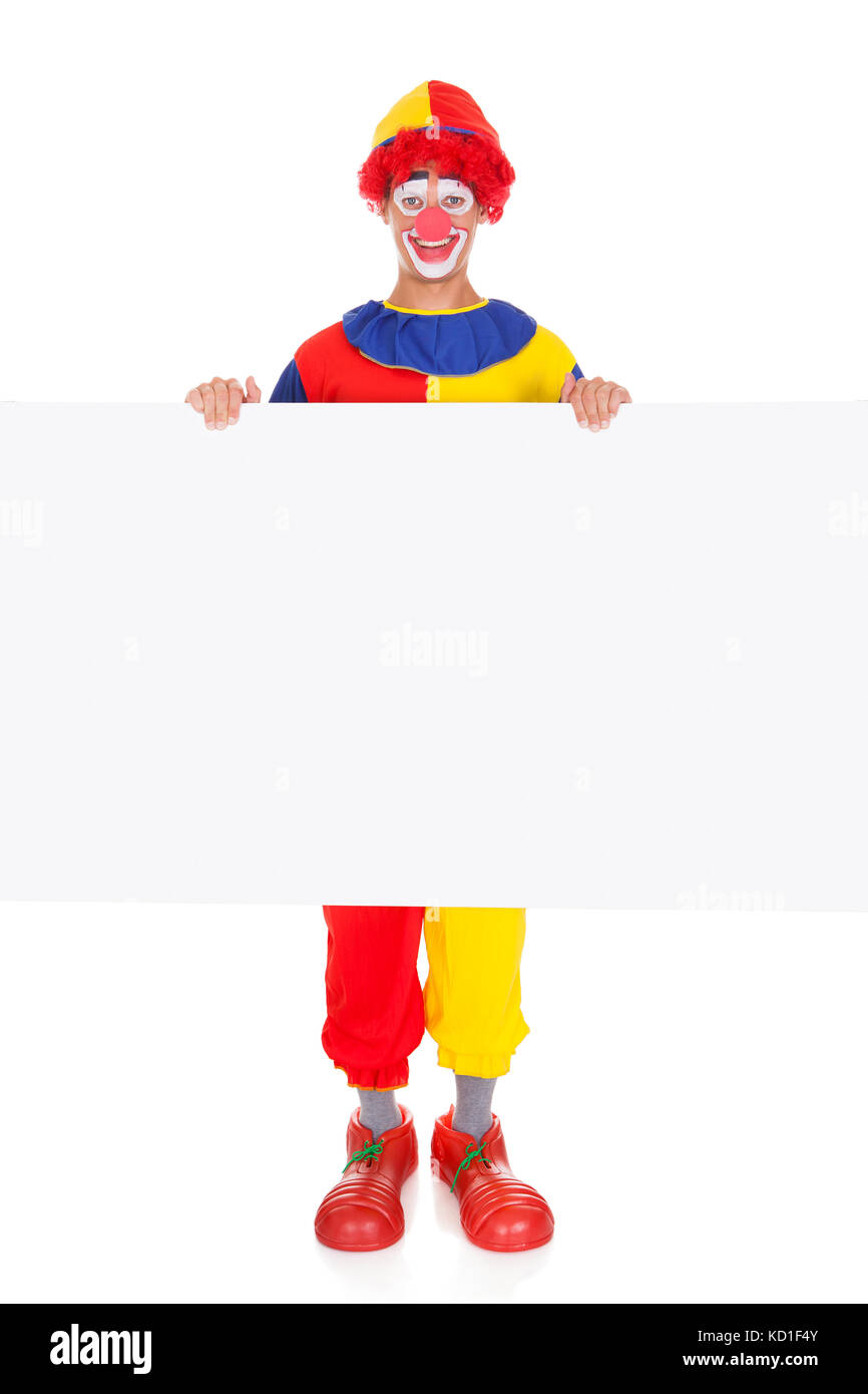 Portrait Of A Happy Joker Holding Blank Placard sur fond blanc Banque D'Images