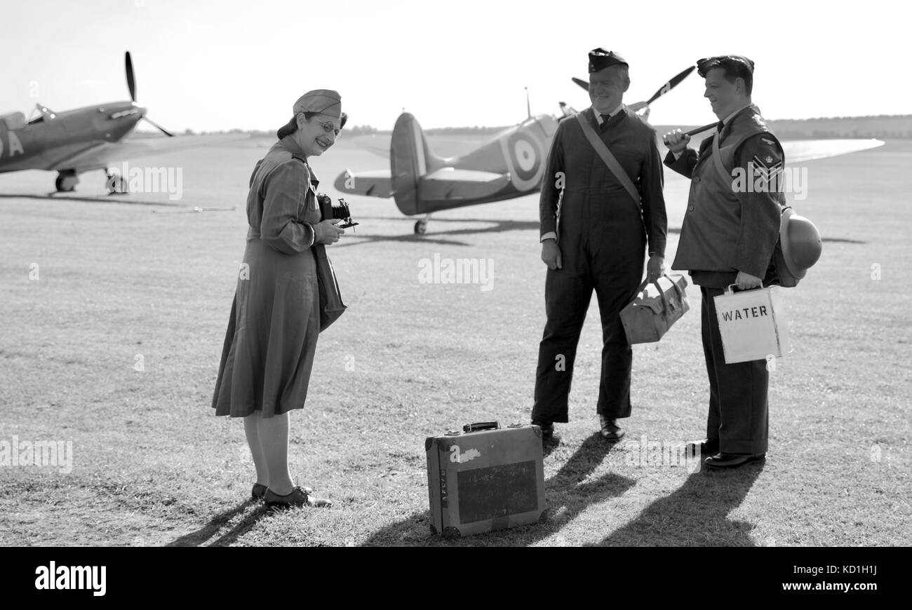 Reconstitution d'une dame de prendre une photo de deux hommes de service avec Superrmarine Spitfire dans l'arrière-plan à l'IWM Duxford Banque D'Images
