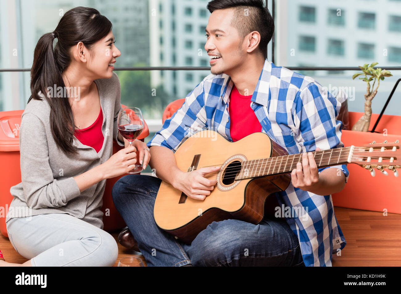 Après déménagement ensemble jeune homme joue pour sa chanson d'amour girlfrie Banque D'Images
