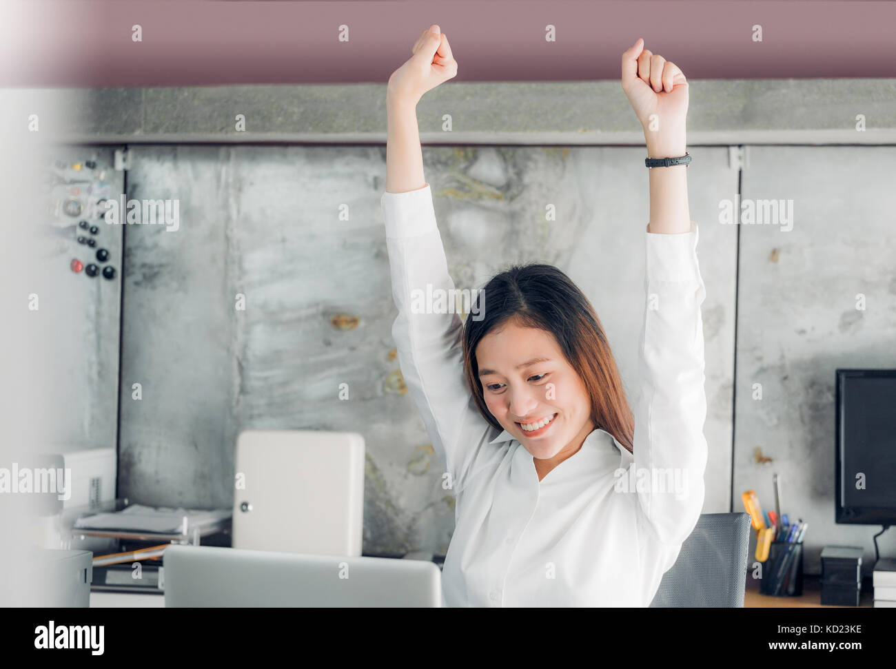 Asian businesswoman soulever jusqu'à bras qui s'étend en face de 24 à partir de travaux sur l'écran de l'ordinateur portable à l'office de tourisme,office concept de vie Banque D'Images