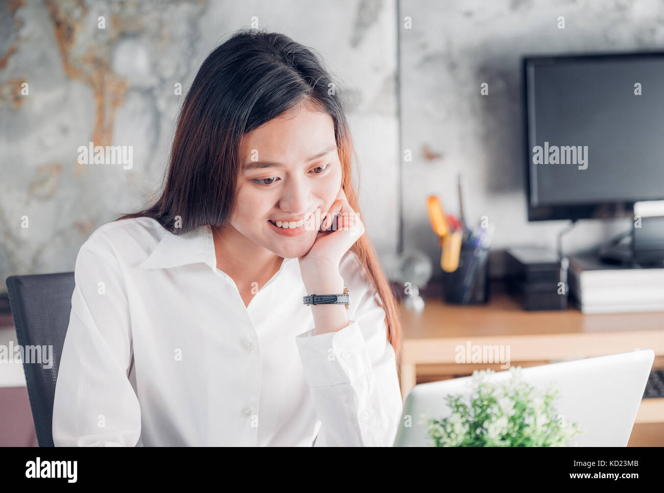 Asian businesswoman looking at laptop computer et visage souriant et de repos avec des professionnels de l'émotion à partir de la bonne nouvelle de la réussite commerciale dans la maison de Banque D'Images