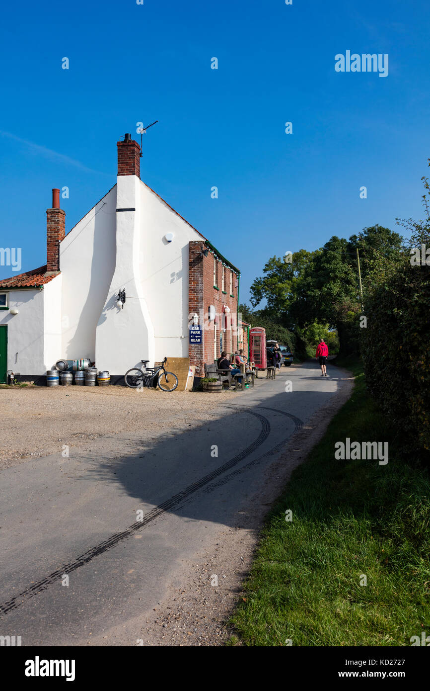 Un traditionnel pub Norfolk près de Horsey, la tête de Nelson, avec un téléphone rouge fort à l'extérieur et les clients sur des bancs, Norfolk, UK Banque D'Images