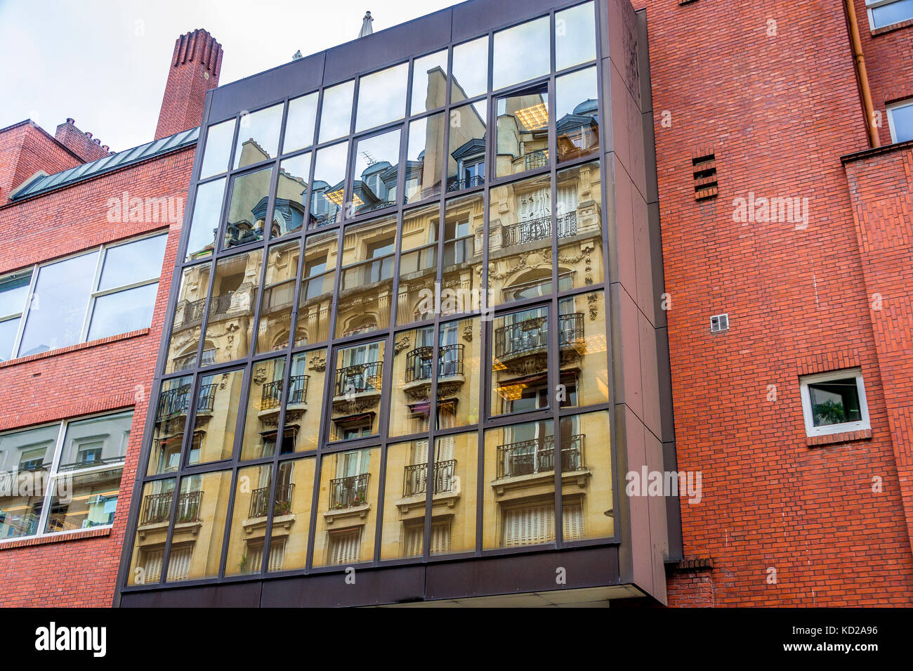 De beaux appartements dans une rue parisienne se reflètent dans des fenêtres de style plus moderne. Banque D'Images