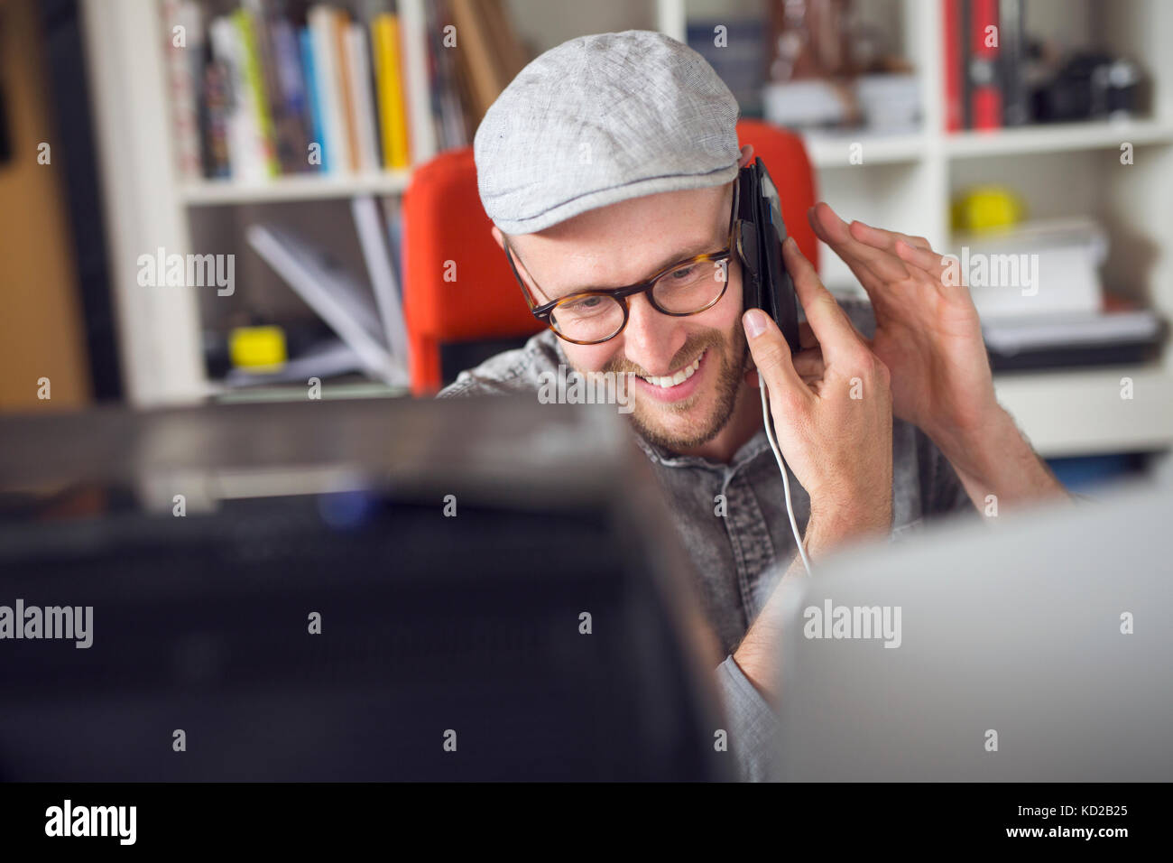 Mid adult man smiling while using phone Banque D'Images