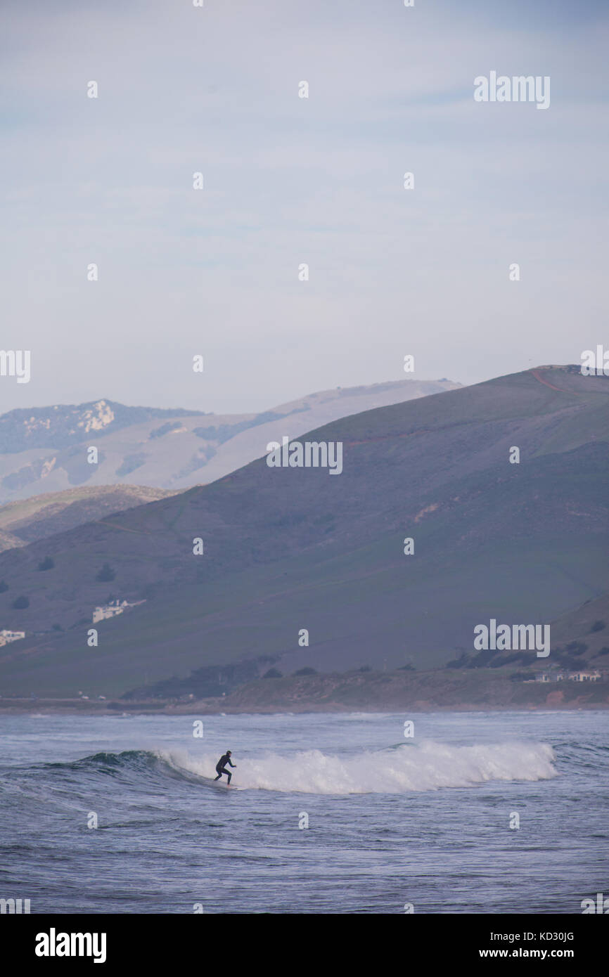 Jeune homme surf surfer des vagues de l'océan, Morro Bay, Californie, USA Banque D'Images