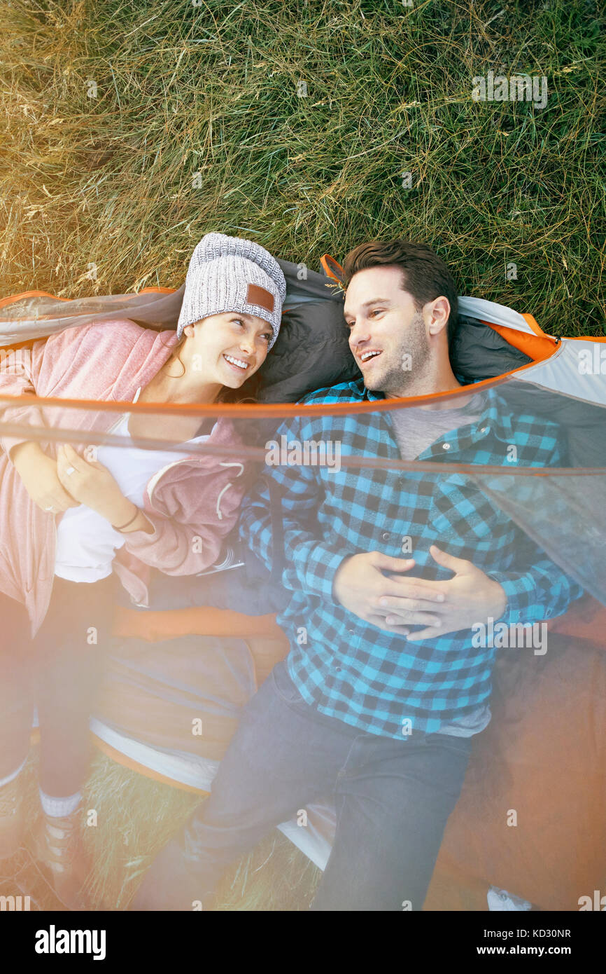 Couple lying in tent, les chefs en dehors de tente, smiling, portrait Banque D'Images
