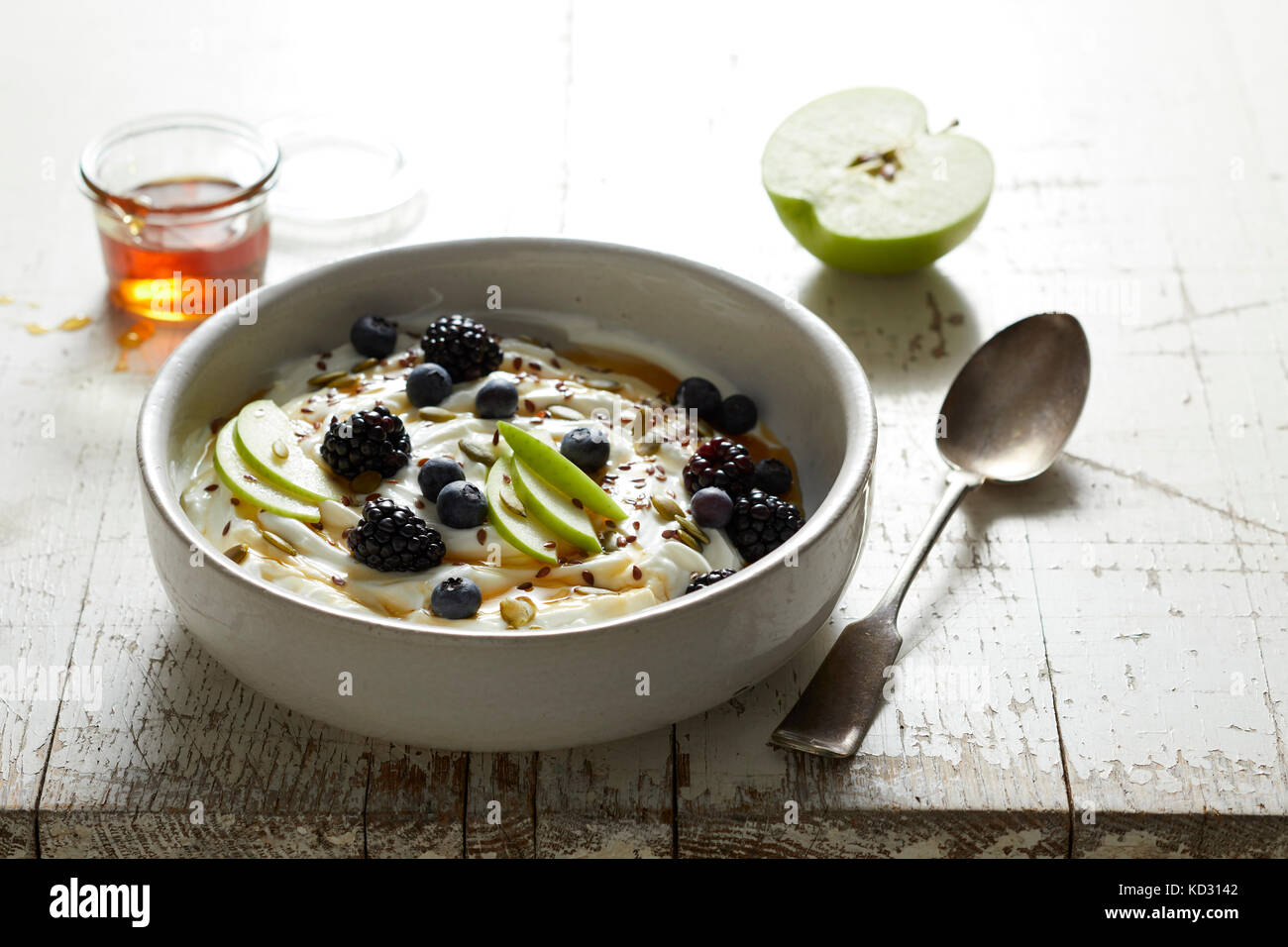 Yaourt à la grecque avec Apple, les mûres, les bleuets et le miel Banque D'Images