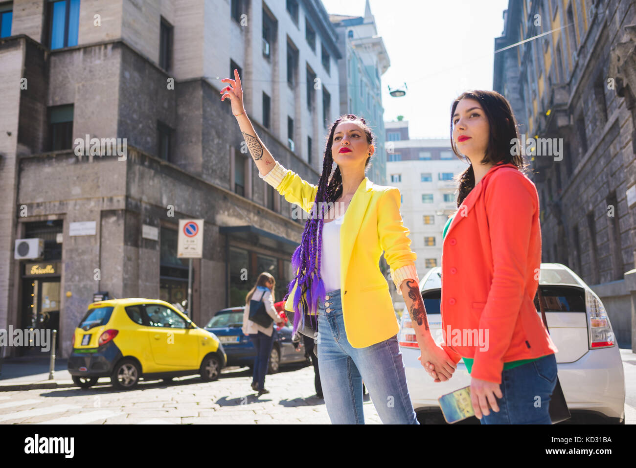 Femme en ville hailing taxi, Milan, Italie Banque D'Images