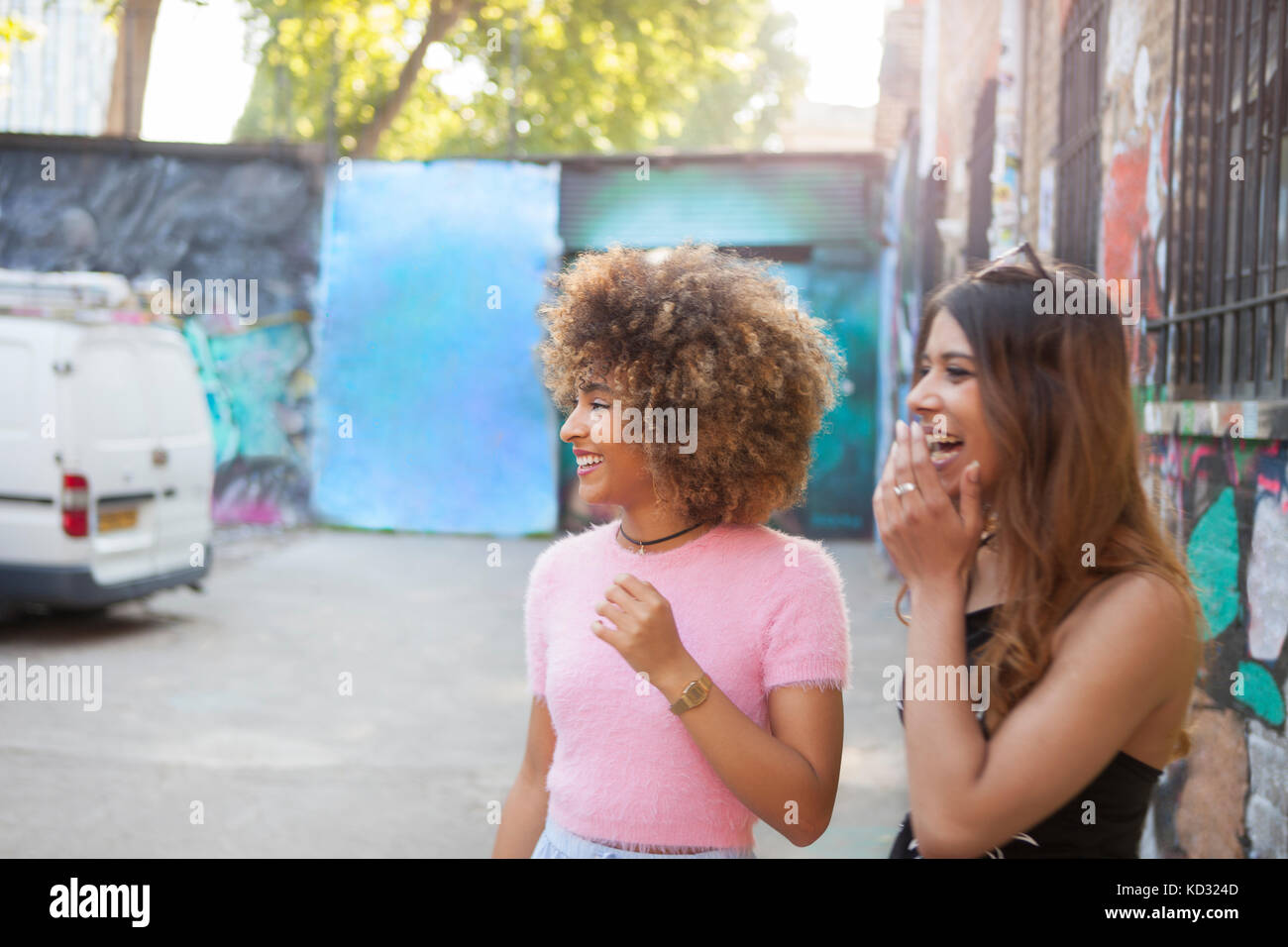 Deux jeunes femmes en rue, à l'écart, rire Banque D'Images