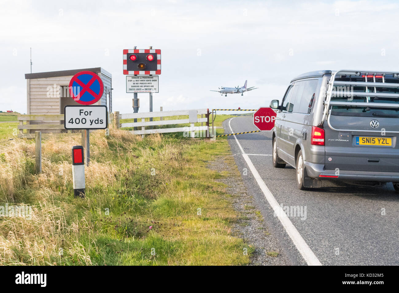 Aéroport de Sumburgh - avion arrivant sur une piste qui est traversée par une route contrôlée par un passage à niveau, Shetland Islands, Écosse, Royaume-Uni Banque D'Images