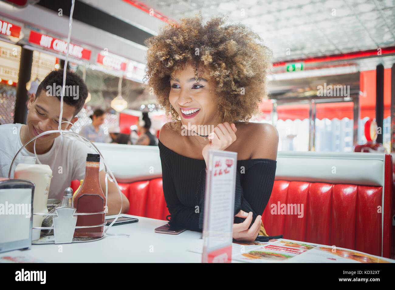 Friends sitting in diner, woman, smiling Banque D'Images