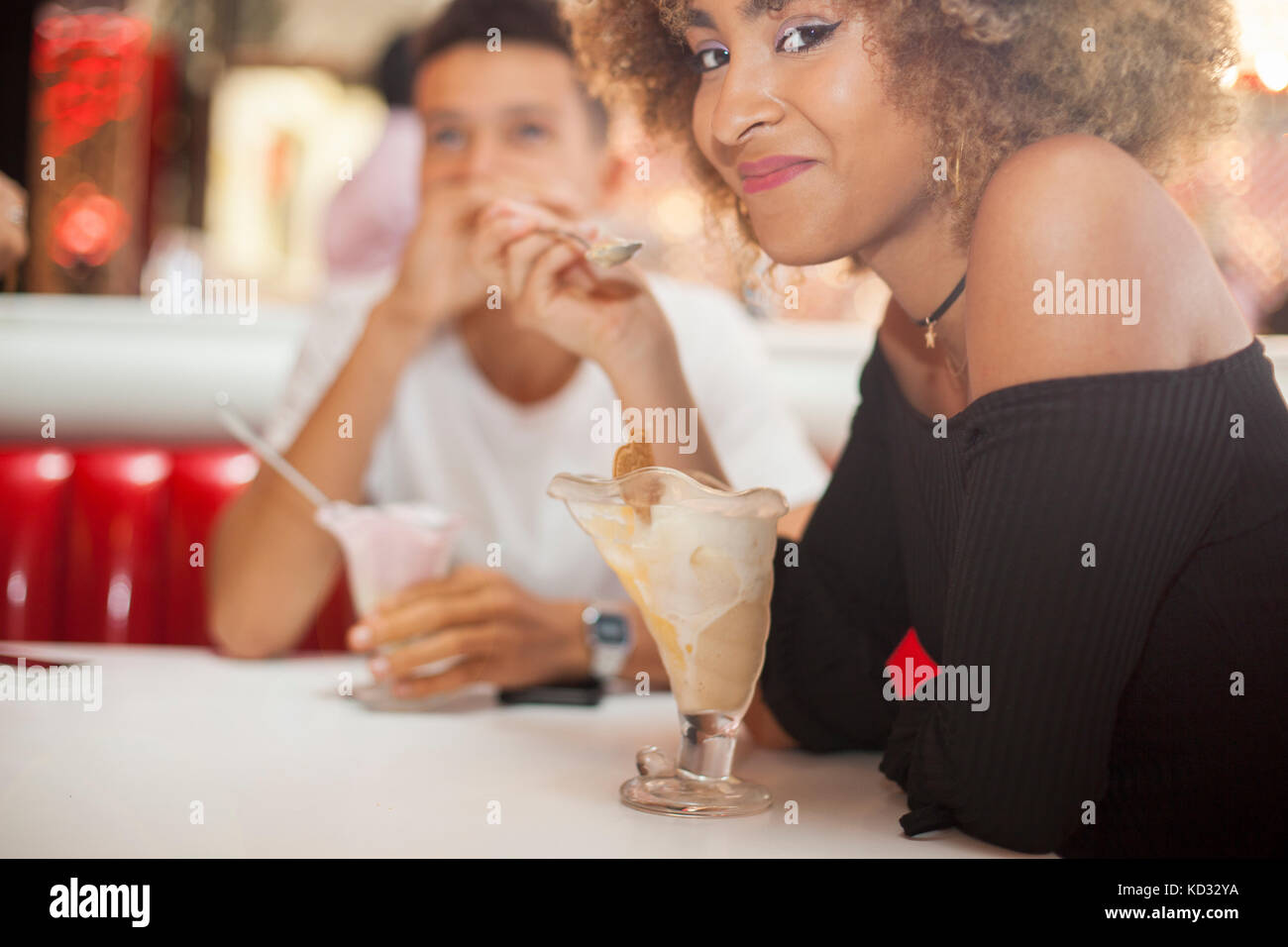 Young couple sitting in diner, manger le dessert, smiling Banque D'Images