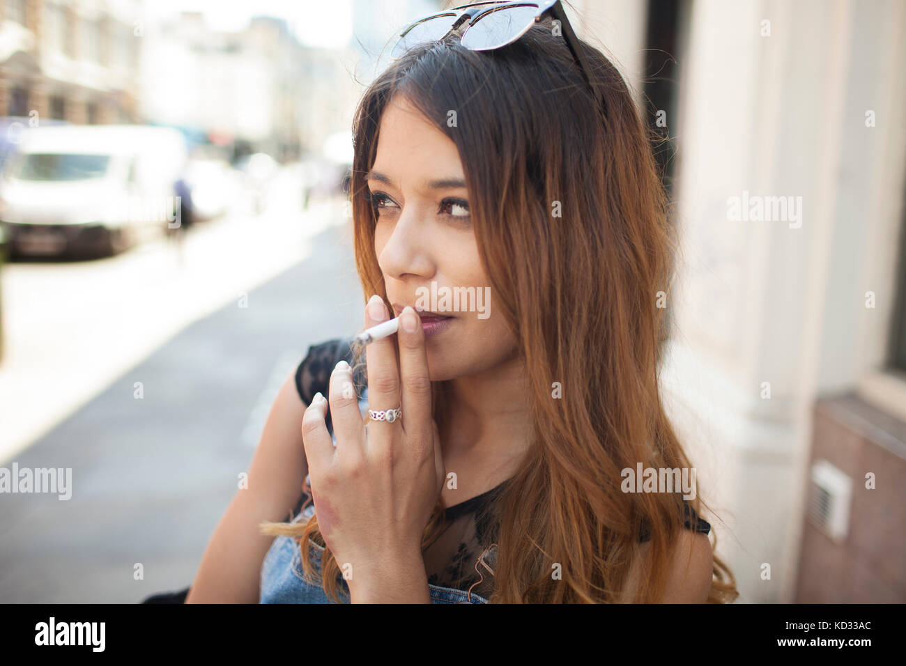 Jeune femme à l'extérieur, fumer cigarette Banque D'Images
