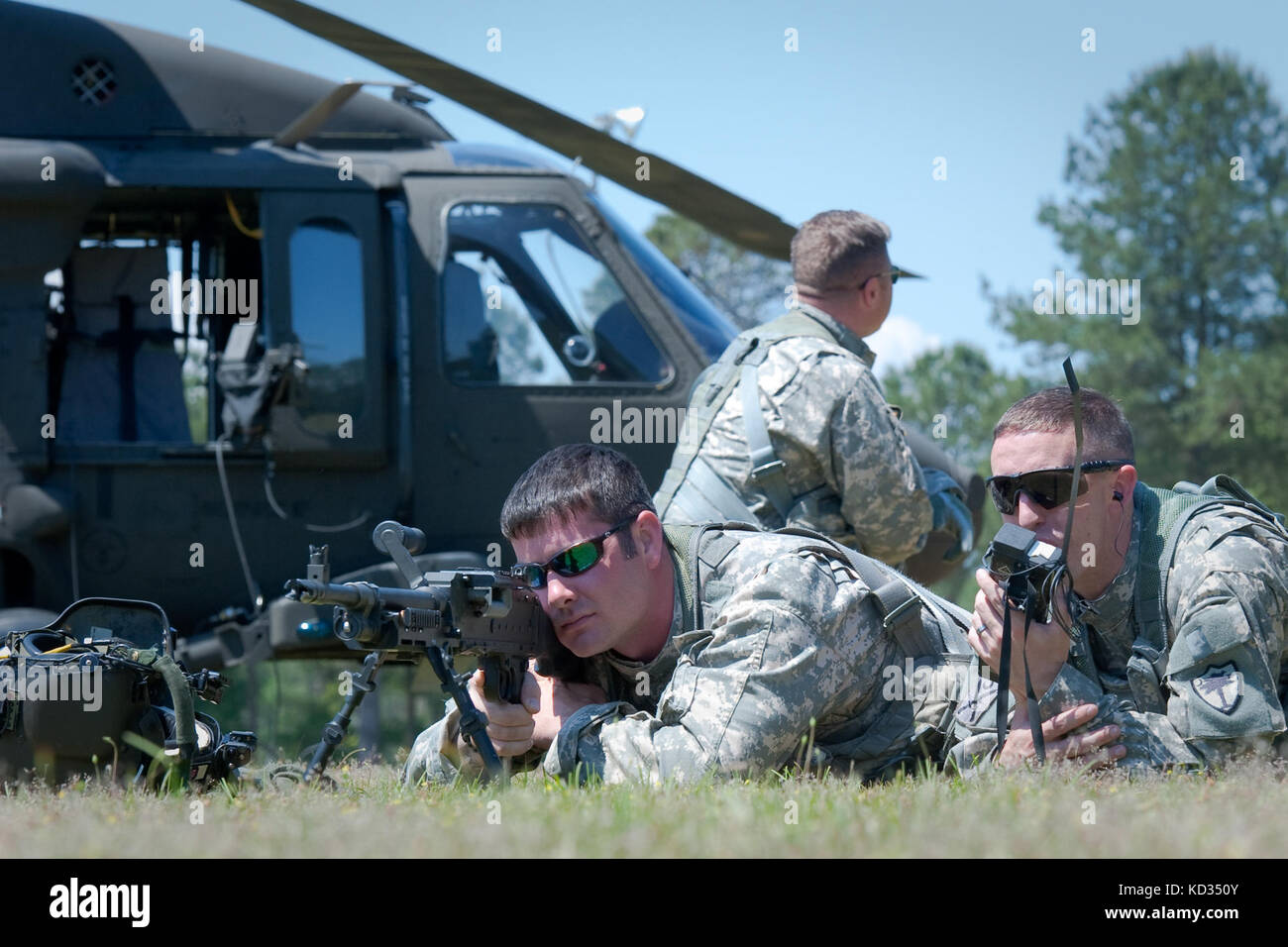 Sgt. Brandon Painter of Company A, 1-111e Bataillon général de soutien de l'aviation, Garde nationale de l'Armée de Caroline du Sud, Utilise un M240 pour aider à établir une défense de périmètre autour d’un hélicoptère UH-60 Black Hawk de l’armée américaine, tandis que l’Adjudant Joshua O’Handley appelle à un MEDEVAC dans le cadre d’un exercice de récupération du personnel et d’entraînement d’avions déportés au McCrady Training Centre, à Eastover, en Caroline du Nord, le 3 mai 2015. L'entraînement a permis aux équipages de construire l'expérience et la confiance dans les procédures de rétablissement du personnel en conjonction avec l'exécution des tâches du guerrier de l'Armée de terre pour s'assurer que le Bataillon est préparé Banque D'Images